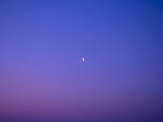 Crescent moon in the early morning over a field