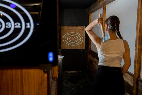 Young Woman Throwing axe in a Casual Indoor Setting