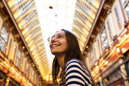 Smiling Young Woman Exploring Indoor London Market