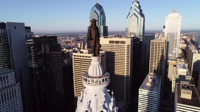 Philadelphia City Hall Tower and bronze statue of William Penn. Cityscape and Beautiful Sunset in Background