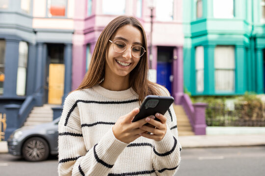 Young woman using smartphone on colorful London street