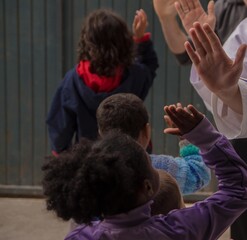 Group of kids giving high five to each other in the schoolyard