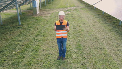 Aerial view of a Solar PV electrician expert analyzing photovoltaic arrays