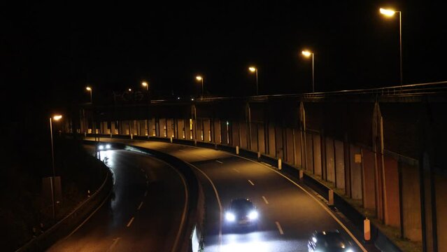 Autos kommen auf die Br&uuml;cke zugefahren bei Dunkelheit und leichtem Regen