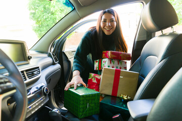 Smiling latin woman in the car with a lot of christmas gifts