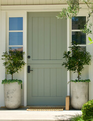 cottage with sage green Dutch door and citrus topiaries