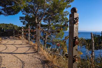 Fence with love padlocks on the trail. Town: Makarska, Croatia