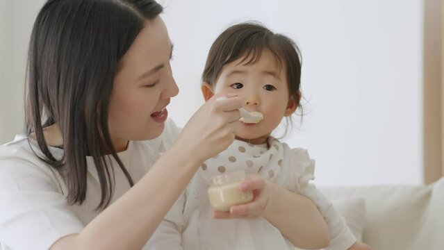 赤ちゃんに離乳食を食べさせるママ（育児・子育て・家族・ファミリー）