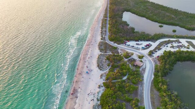 Aerial View Of Blind Pass Beach On Manasota Key, USA. Many People Enjoying Vacation Time Swimming In Gulf Water And Relaxing On Warm Florida Sun At Sunset