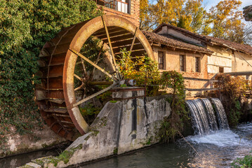 Rusty disused mill paddle wheel near canal in Italian Po Valley