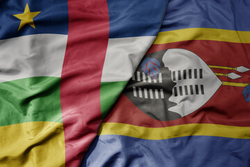 big waving national colorful flag of eswatini and national flag of central african republic .
