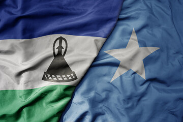 big waving national colorful flag of somalia and national flag of lesotho .