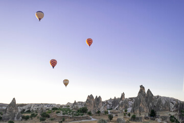 Fototapeta na wymiar hot air balloons flying over the fairy chimneys, at the Goreme airfield at dawn, Cappadocia, Red Valley, Turkey, Goreme National Park, horizontal