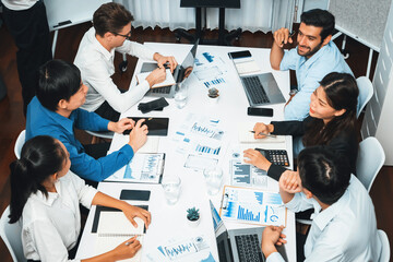 Analyst team utilizing BI Fintech to analyze financial data at table in meeting room. Businesspeople analyzing BI dashboard power for business insight and strategic marketing planning. Prudent