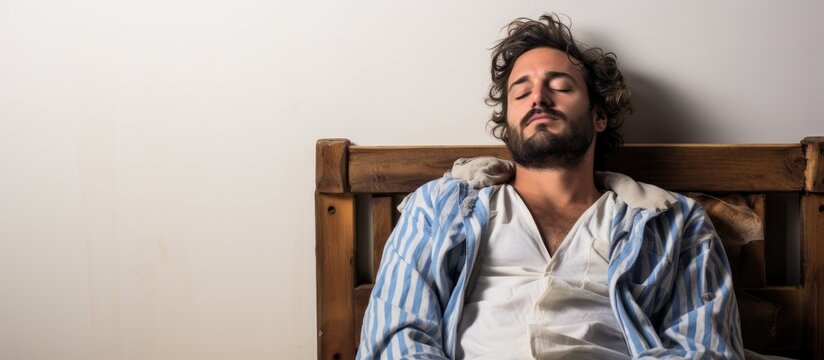 In The Concept Of A Peaceful And Cute Lifestyle, A Young Adult Man With A Beard Is Seen Relaxing In His Pajamas, Hiding From People, Isolated In A White Background, Enjoying A Good Sleep, While His