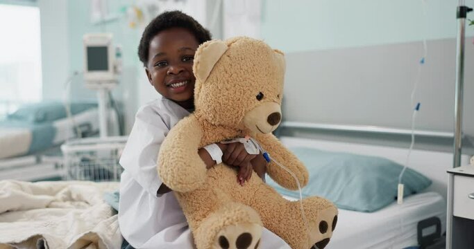 African boy child, hospital and teddy bear on bed with face, smile and rest for recovery for healthcare treatment. Patient kid, happy and portrait to relax, clinic and hug with toys after surgery