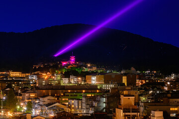 Kyoto City historic precinct with the purple blue beam of light projected into the dark sky over...