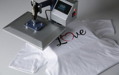 Printing logo. Heat press with t-shirt on white table