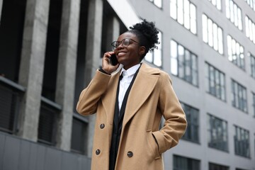 Happy woman talking on smartphone outdoors. Lawyer, businesswoman, accountant or manager