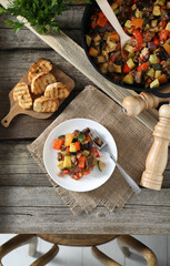 Delicious ratatouille served on wooden table, flat lay
