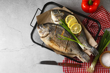 Seafood. Delicious baked fish served with green onion and lemon on light textured table, flat lay with space for text