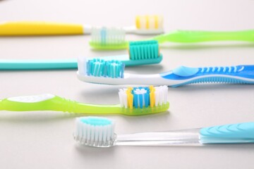 Many different toothbrushes on light background, closeup