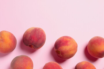 Many whole fresh ripe peaches on pink background, flat lay. Space for text
