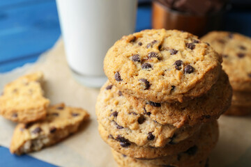 Tasty chocolate chip cookies and glass of milk on table, closeup
