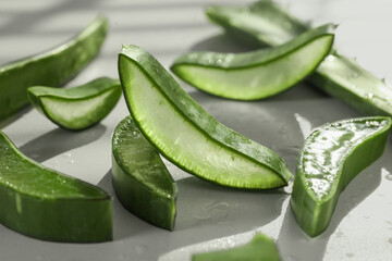 Fresh aloe vera pieces on white table, closeup