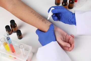 Doctor doing skin allergy test at light table, closeup