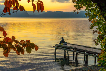 夜明けの十和田湖と釣り人