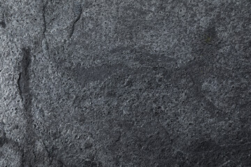Texture of dark grey stone surface as background, closeup