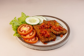 Tempe Penyet is Indonesian Street Food, Fried Tempeh Smashing with Red Chili, Garlic and Salt or Sambal.