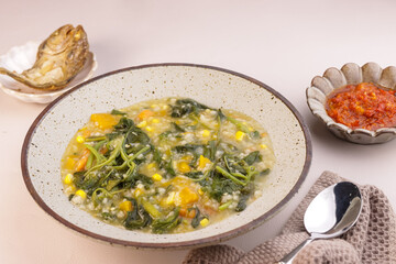 Bubur Manado or Bubur Tinutuan is Manado Traditional Porridge, Rice Mixed with Pumpkin, Corn, Vegetables. Served with Salted Fish and Sambal or Chili Sauce.