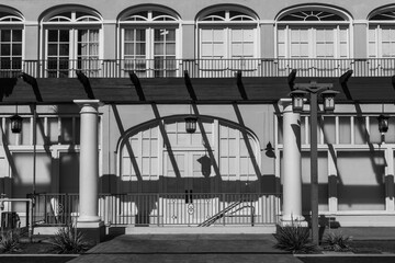 Side view of historic two story building in black and white photography with arched windows,...