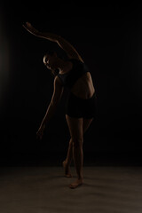 Fit Women Performing Yoga Postures Depicting Fitness in dull light and black background wearing black sports wear 