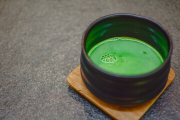 Matcha green tea on black background. Matcha bowl.