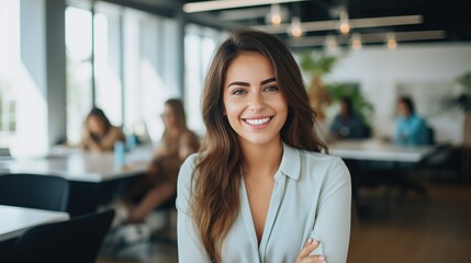 Photo of beautiful happy woman looking at camera while sitting at office