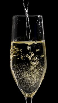 Slow motion champagne pouring in champagne glass macro closeup