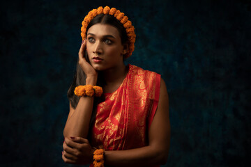 portrait of a tribal woman wearing orange flower garland and orange saree 