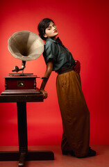 portrait of a woman with a gramophone and cigarettes in red background 