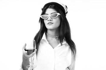 woman holding vine glass and cigar in hand wearing sunglasses and white top 