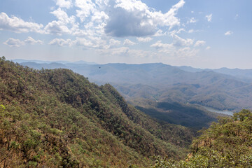 View to the hills from the slopes of Doi Nangmo mountain at midday in February near Chiang Mai, Northern Thailand.