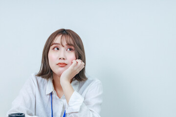 	頬杖をつき考え事をする女性｜左上目線