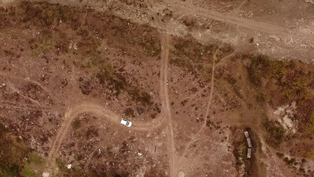 Top down drone footage of white car driving in Bedni Bugyal meadow in Chamoli, Uttarakhand, India