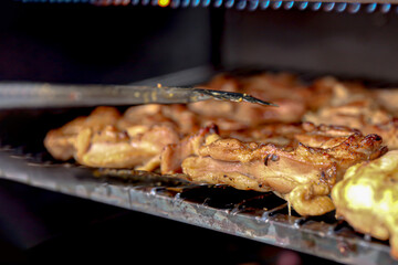 Close up of the process of grilling chicken fillets, some chickens are out of focus and some are focused on the chicken