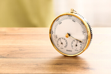 Aneroid barometer on wooden table in room, closeup