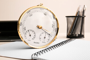 Aneroid barometer on opened notebook, closeup