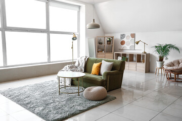 Interior of light living room with green armchair, coffee table and standard lamp