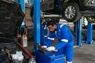 Fototapeta na wymiar Auto mechanic in blue uniform are repair and maintenance auto engine is problems at car repair shop.